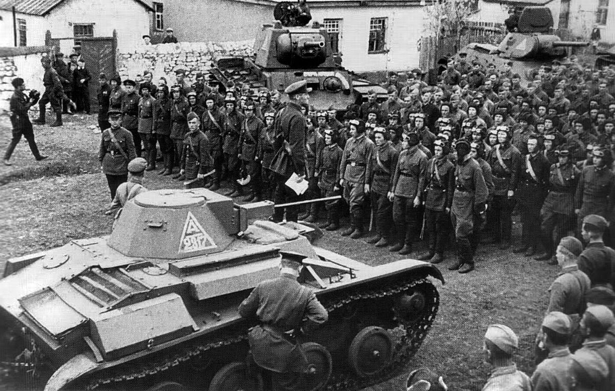 A Commissar stands next to a T-60 whilst giving a speech to Soviet tank crews in May, 1942.