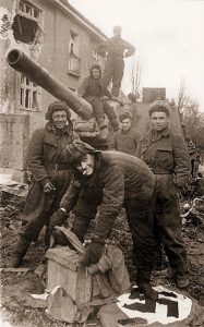 The crew of an ISU-152 appear to be cleaning their boots with Nazi banners