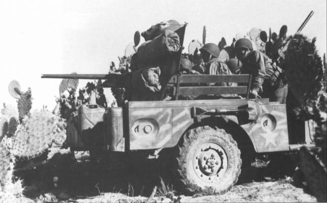 Nice photo of a brush mud-painted M6 GMC in Tunisia using cactus to camouflage.